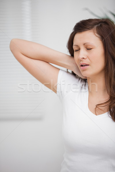 Woman touching her painful neck in a room Stock photo © wavebreak_media