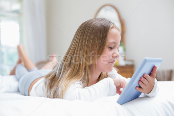 Little girl using tablet pc in the bed  Stock photo © wavebreak_media