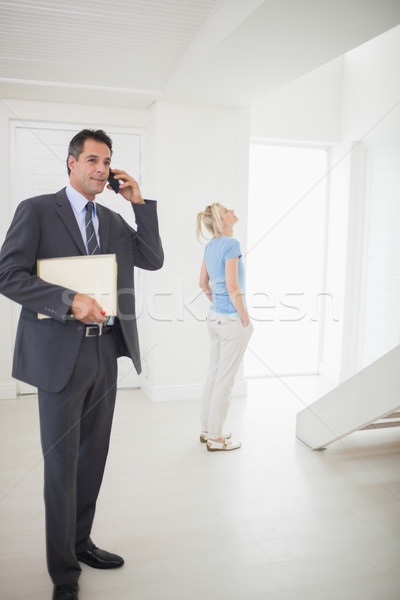 Real estate agent on call with blurred woman in background Stock photo © wavebreak_media