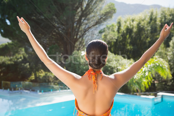 Brunette in sarong standing with arms out by the pool  Stock photo © wavebreak_media
