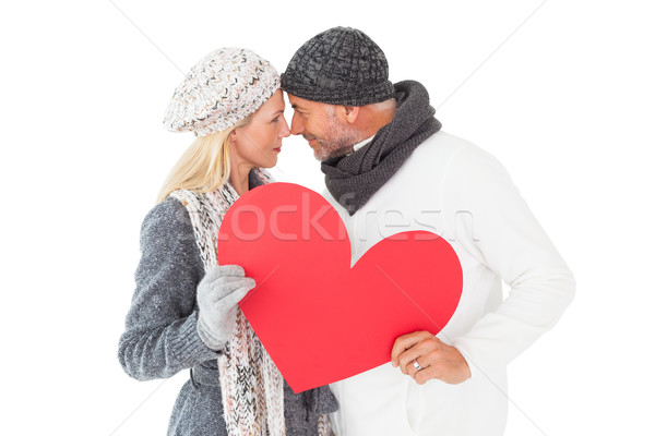 Souriant couple hiver mode posant forme de coeur Photo stock © wavebreak_media