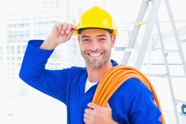 Confident repairman wearing hard hat while holding wire roll Stock photo © wavebreak_media