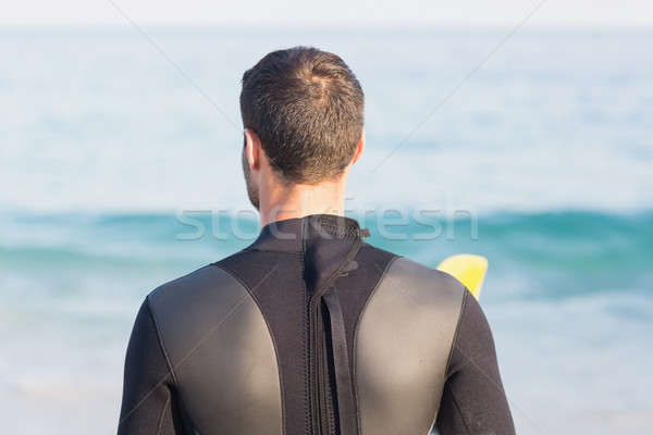 Man in wetsuit with a surfboard on a sunny day Stock photo © wavebreak_media