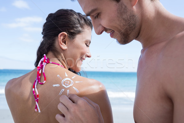 Handsome man putting sun tan lotion on his girlfriend Stock photo © wavebreak_media