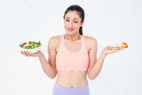 Pretty brunette holding pizza and salad Stock photo © wavebreak_media