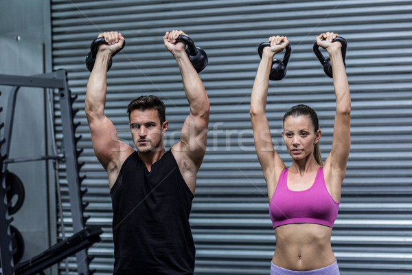 A muscular couple lifting kettlebells Stock photo © wavebreak_media