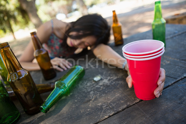 Drunken woman sleeping on the table and holding a glass of beer Stock photo © wavebreak_media