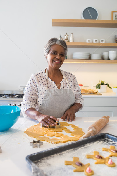 Stock photo: Smiling senior woman preparing cookies in kitchen