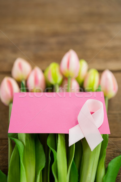 Close-up of pink Breast Cancer Awareness ribbon with blank card on fresh tulips Stock photo © wavebreak_media
