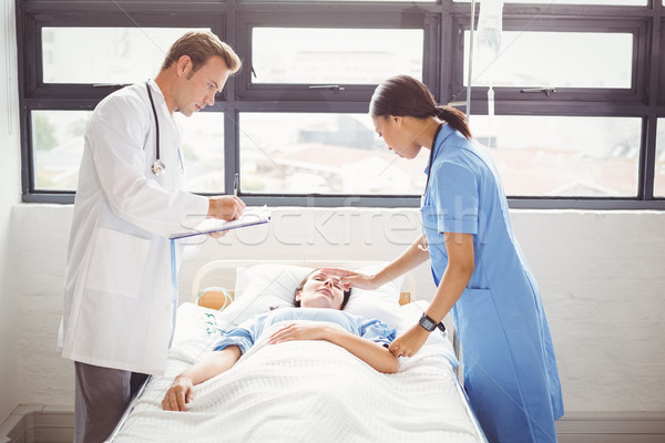 Médico enfermera paciente stand alrededor cama Foto stock © wavebreak_media