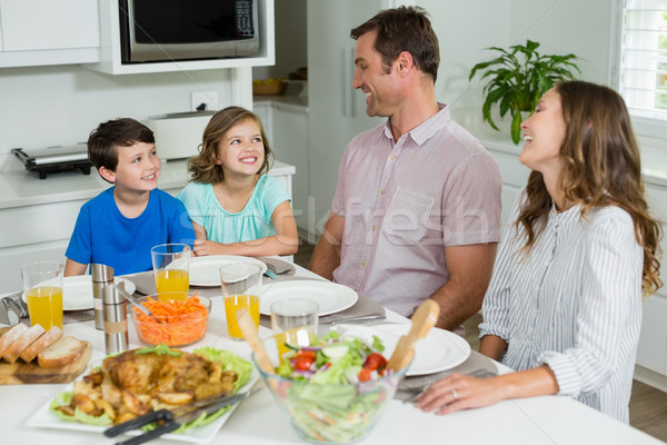 Smiling family interacting with each other while having lunch together Stock photo © wavebreak_media