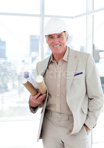 Stock photo: Senior architect with a hardhat holding blueprints