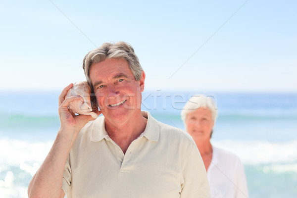 Hombre escuchar Shell esposa detrás mujer Foto stock © wavebreak_media