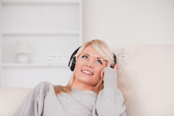 Csinos szőke nő fejhallgató kanapé nappali Stock fotó © wavebreak_media