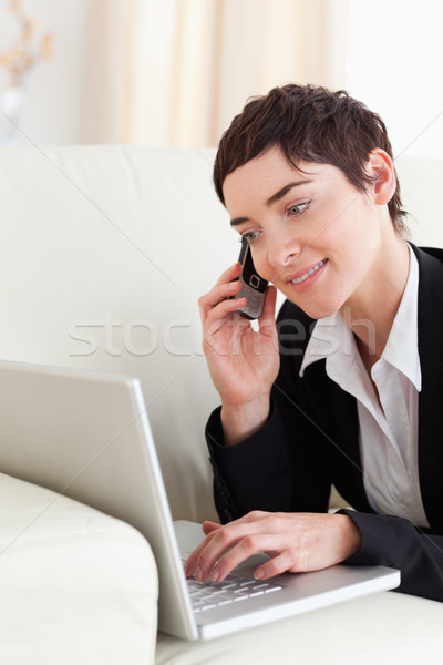 деловая женщина диван ноутбука телефон гостиной улыбка Сток-фото © wavebreak_media