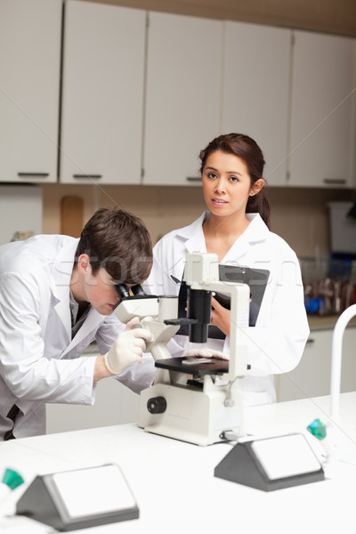 [[stock_photo]]: Portrait · scientifique · regarder · microscope · collègue · posant