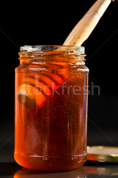 Honey full jar with a honey dipper against a black background Stock photo © wavebreak_media