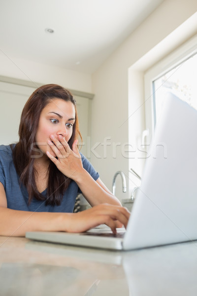 étonné femme utilisant un ordinateur portable cuisine ordinateur maison [[stock_photo]] © wavebreak_media