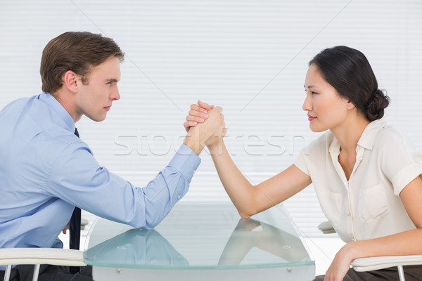Business couple arm wrestling at desk Stock photo © wavebreak_media