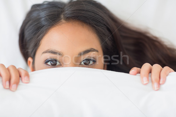 Young girl peeking from under the duvet Stock photo © wavebreak_media