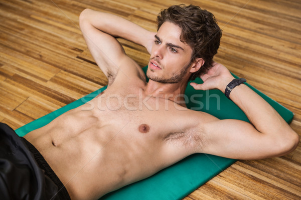 Stock photo: Fit shirtless man doing sit ups in fitness studio