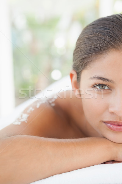 Beautiful brunette lying on massage table with salt scrub on bac Stock photo © wavebreak_media