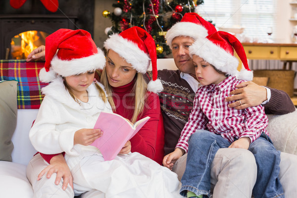 Festive family wearing santa hat while reading on the couch Stock photo © wavebreak_media