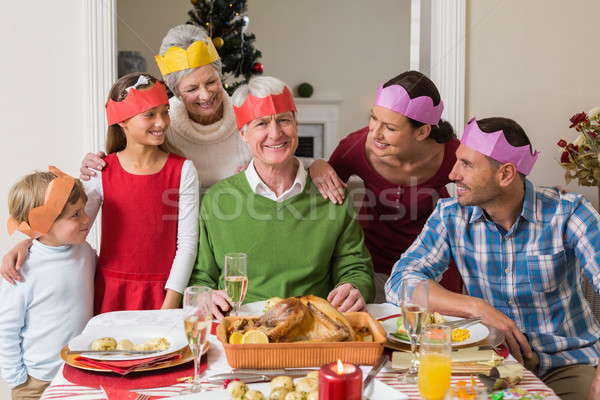 Happy extended family in party hat at dinner table Stock photo © wavebreak_media