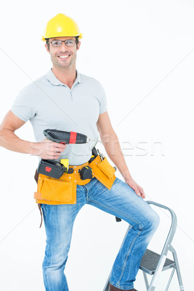 Worker holding drill machine on step ladder Stock photo © wavebreak_media