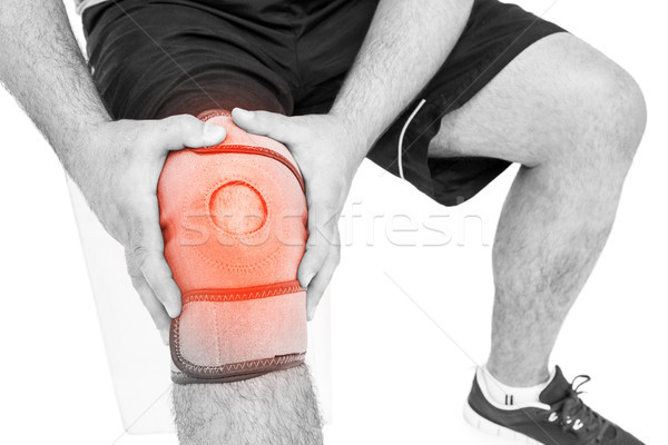Man suffering with knee cramp against white background Stock photo © wavebreak_media