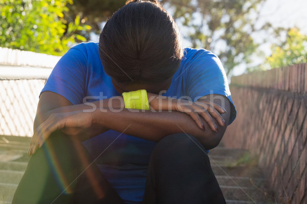Upset woman sitting on staircase in the boot camp Stock photo © wavebreak_media