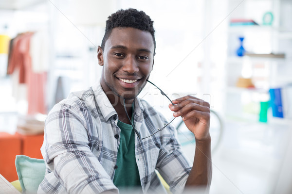 Smiling male executive holding spectacles in office Stock photo © wavebreak_media