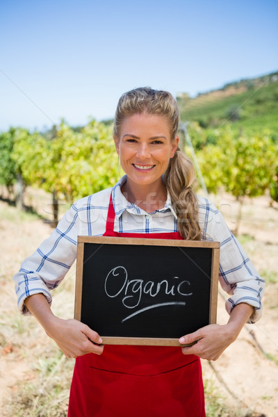 Portrait of happy woman holding slate with text in vineyard Stock photo © wavebreak_media