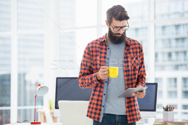 Hipster using tablet and drinking coffee Stock photo © wavebreak_media