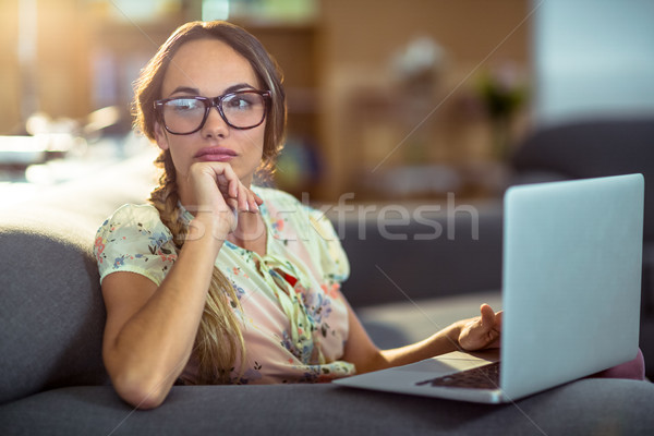 Figyelmes nő ül kanapé laptopot használ iroda Stock fotó © wavebreak_media