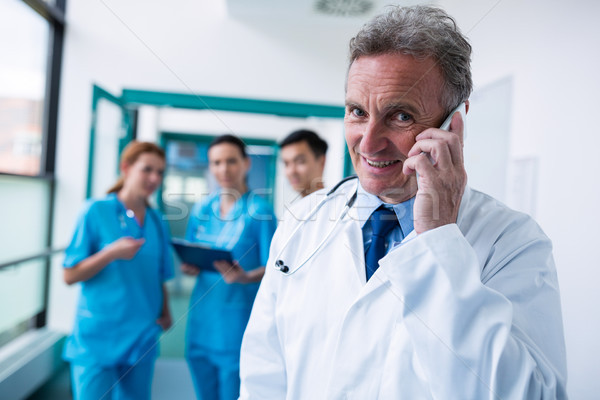 портрет улыбаясь врач говорить мобильного телефона коридор Сток-фото © wavebreak_media