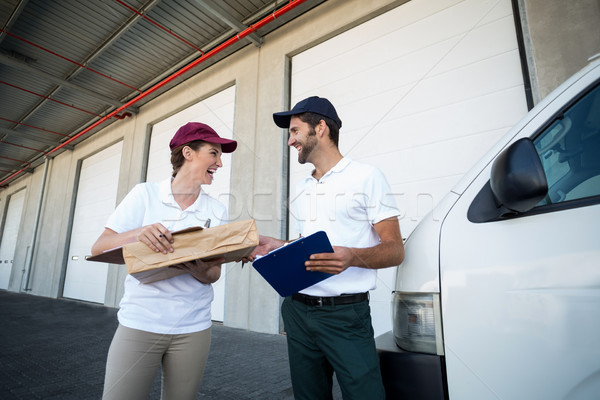 Happy delivery man and woman standing with clipboard and parcel Stock photo © wavebreak_media