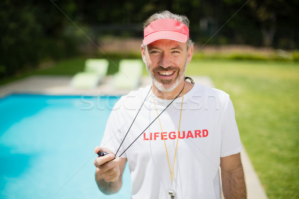 Stock photo: Portrait of swim coach holding stopwatch near poolside