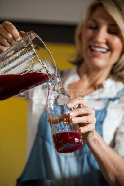 Female staff pouring juice in a bottle Stock photo © wavebreak_media