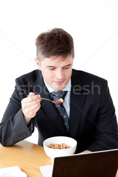 Young businessman using a laptop while having breakfast at home Stock photo © wavebreak_media