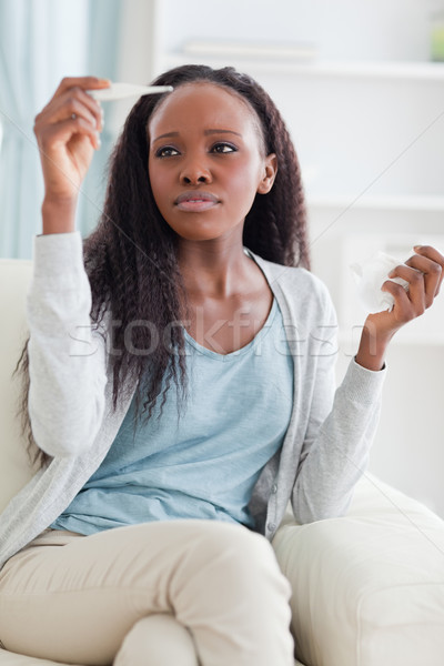 Young woman measuring her temperature on sofa Stock photo © wavebreak_media