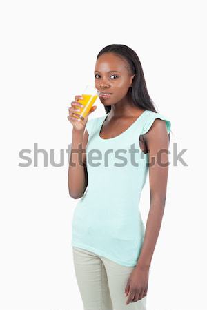 Stock photo: Young woman with a glass of orange juice against a white background