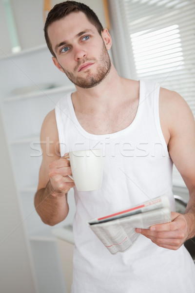 Portrait of a healthy man drinking tea while reading the news in his kitchen Stock photo © wavebreak_media