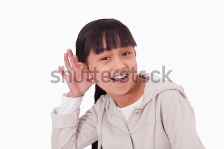 Girl pricking up her ear against a white background Stock photo © wavebreak_media
