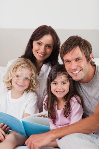 Portrait famille heureuse lecture livre chambre maison [[stock_photo]] © wavebreak_media