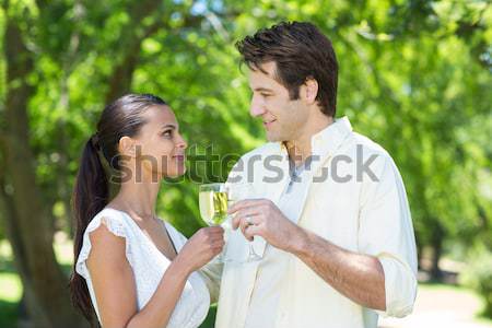 Stock photo: Smiling woman with her arm around her friends shoulder while holding a glass of champage