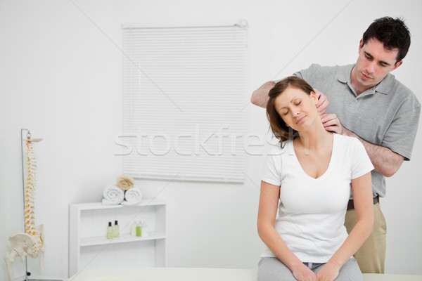 Doctor examining the neck of his patient while standing in a medical room Stock photo © wavebreak_media