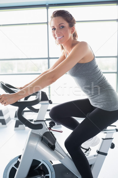 Mujer sonriente equitación ejercicio moto gimnasio sonrisa Foto stock © wavebreak_media