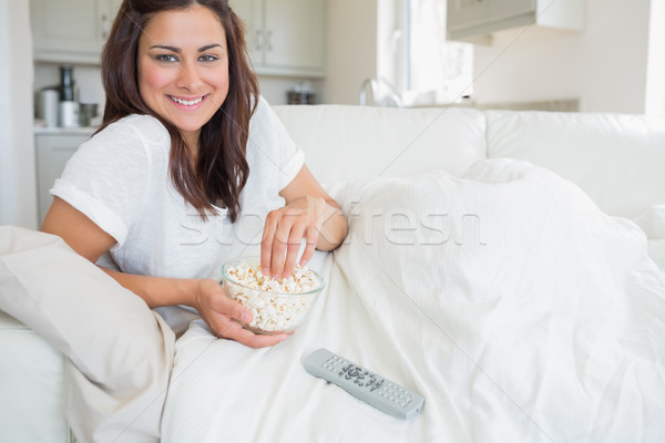 улыбающаяся женщина еды попкорн Смотря телевизор дома счастливым Сток-фото © wavebreak_media