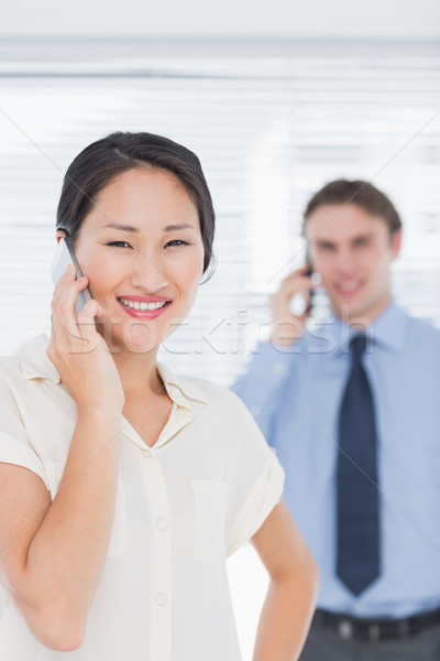 Businesswoman and man using cellphones in office Stock photo © wavebreak_media